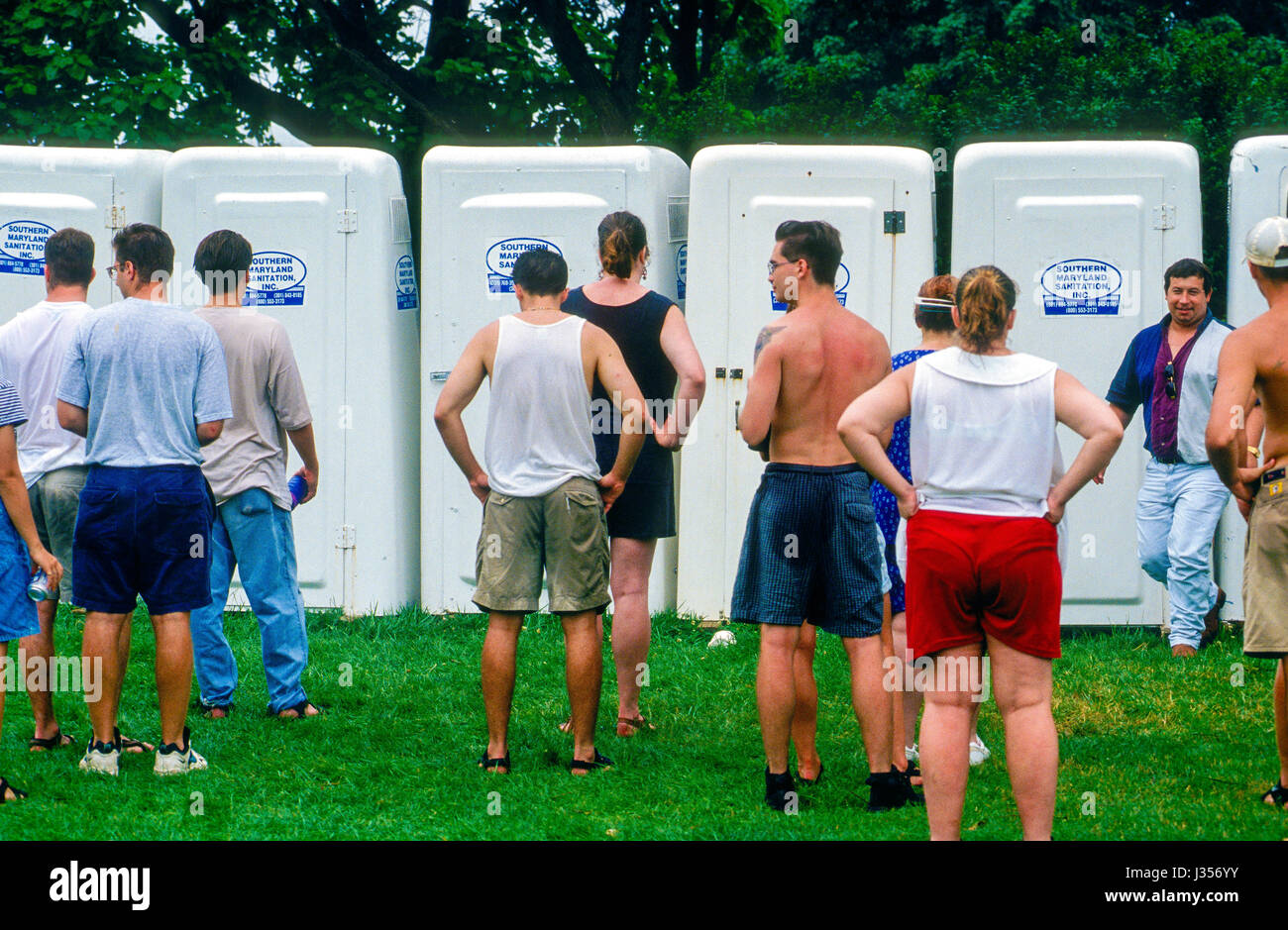 Linea di persone fino a usare il portatile vasino a Woodstock Music Festival in Saugerties, New York, 12 agosto 1994. Foto di Mark Reinstein Foto Stock