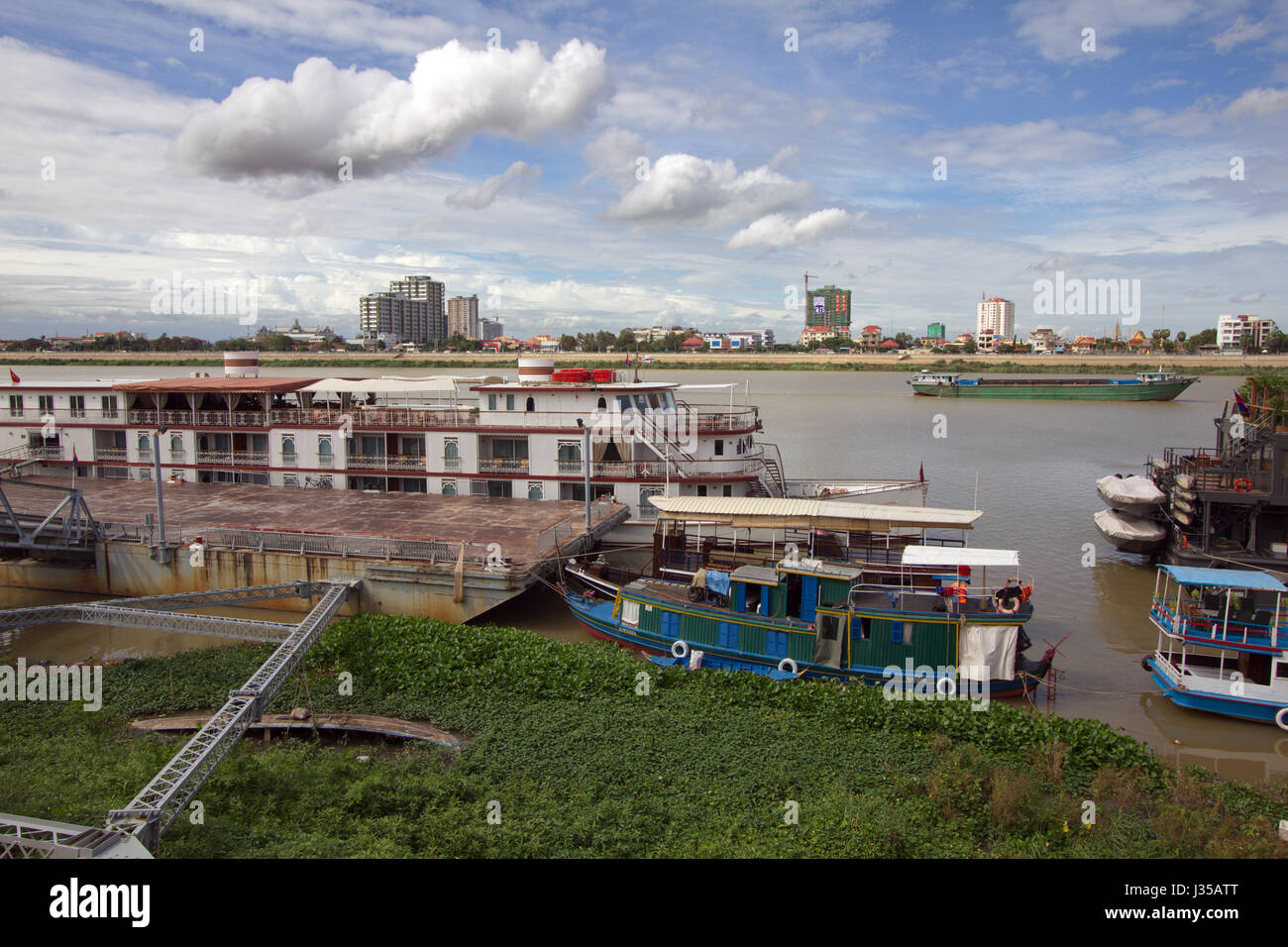 Una scena accanto al fiume Tonle Sap a Sisowath Quay, Phnom Penh, Cambogia, con la popolazione locale a piacere. Foto Stock