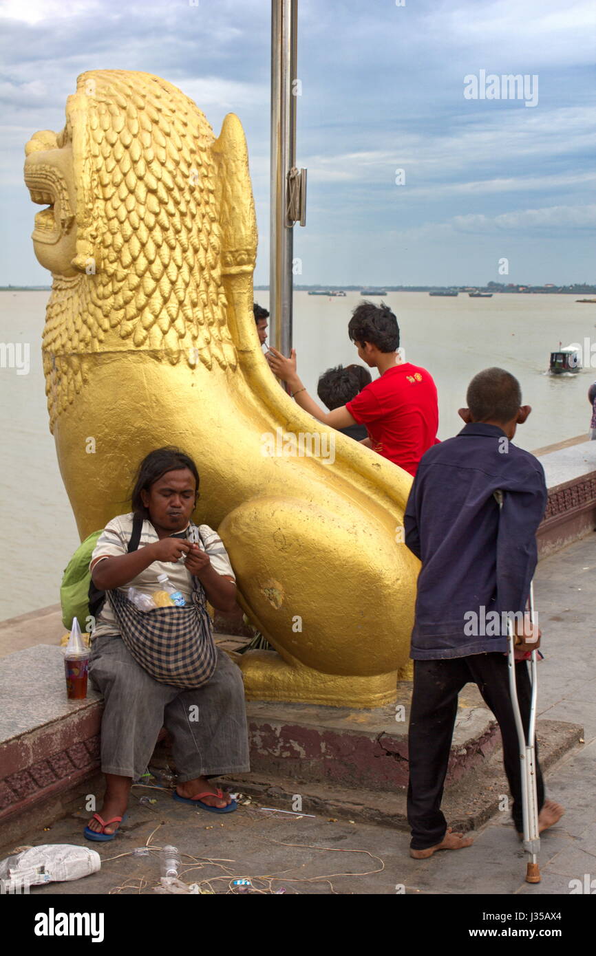 Una scena accanto al fiume Tonle Sap a Sisowath Quay, Phnom Penh, Cambogia, con la popolazione locale a piacere. Foto Stock