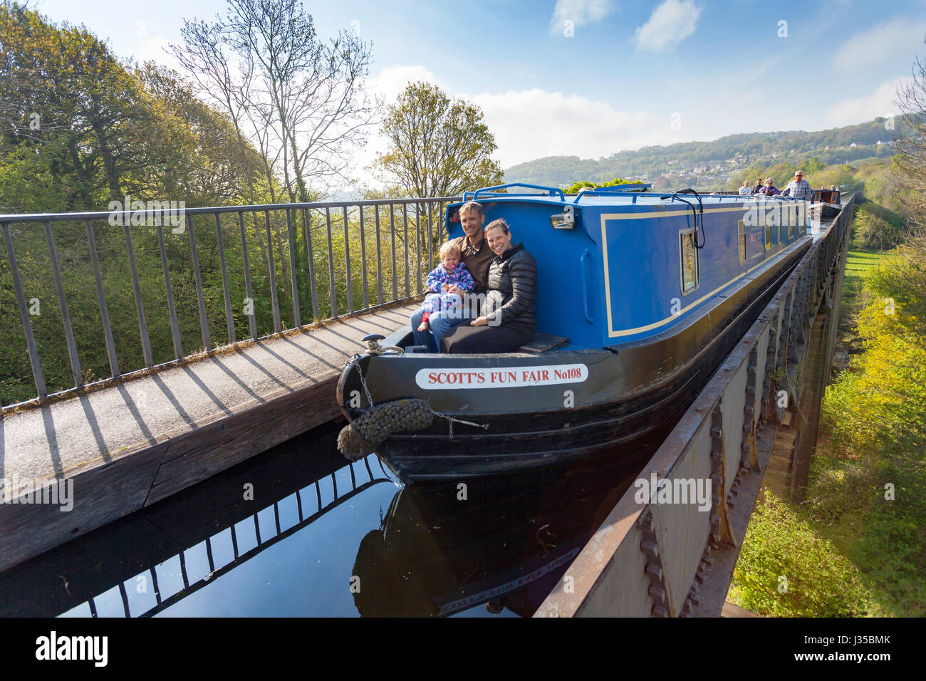 Una famiglia seduta sul lato anteriore di una chiatta sul canale cercando felice come essi attraversano la famosa e popolare attrazione turistica di Acquedotto Pontcysyllte Foto Stock