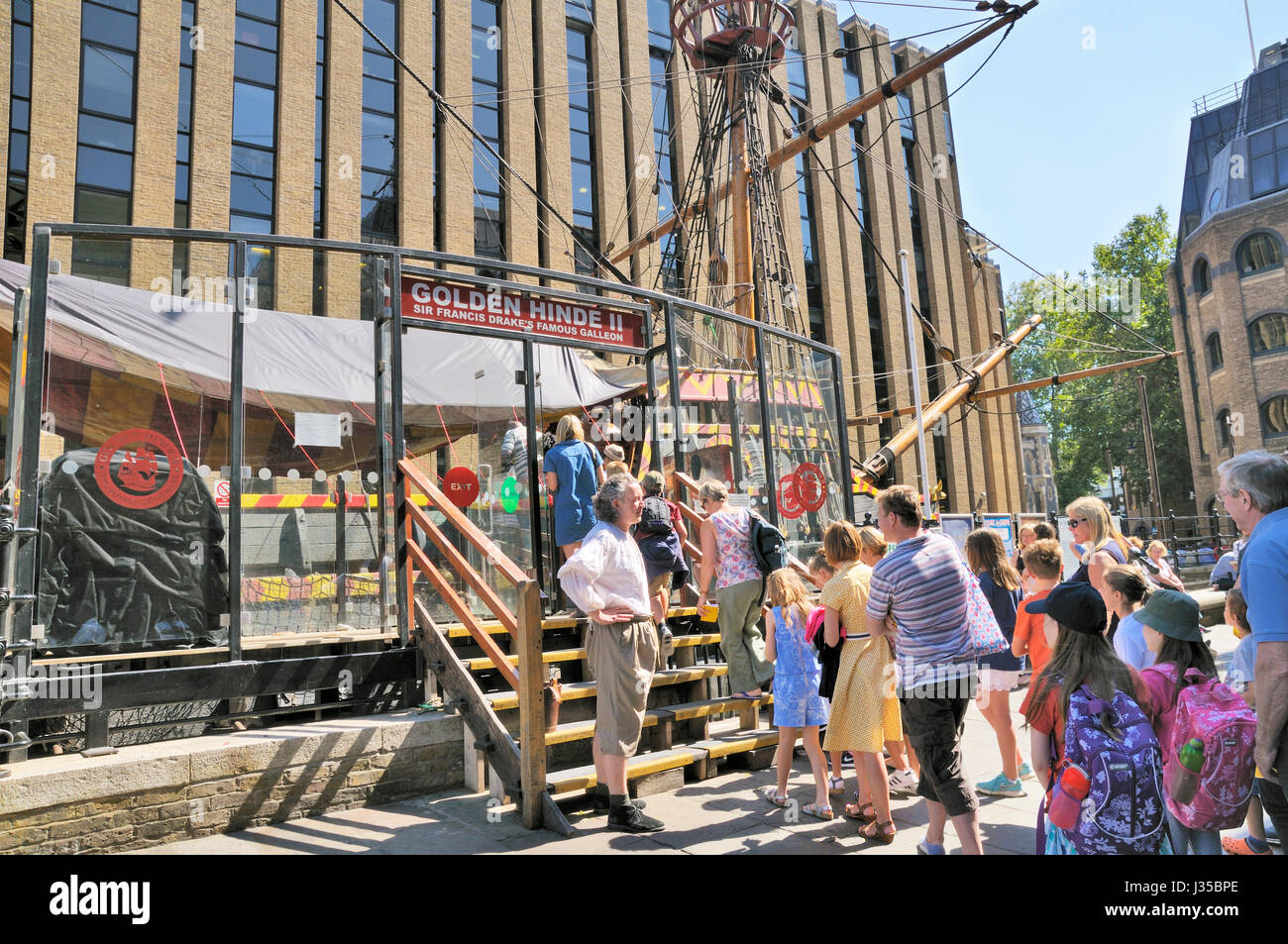 Il Golden Hinde II, Londra, Inghilterra, Regno Unito. Una guida turistica nel periodo dress accoglie i turisti a bordo della replica di Sir Francis Drake's galeone nave. Foto Stock