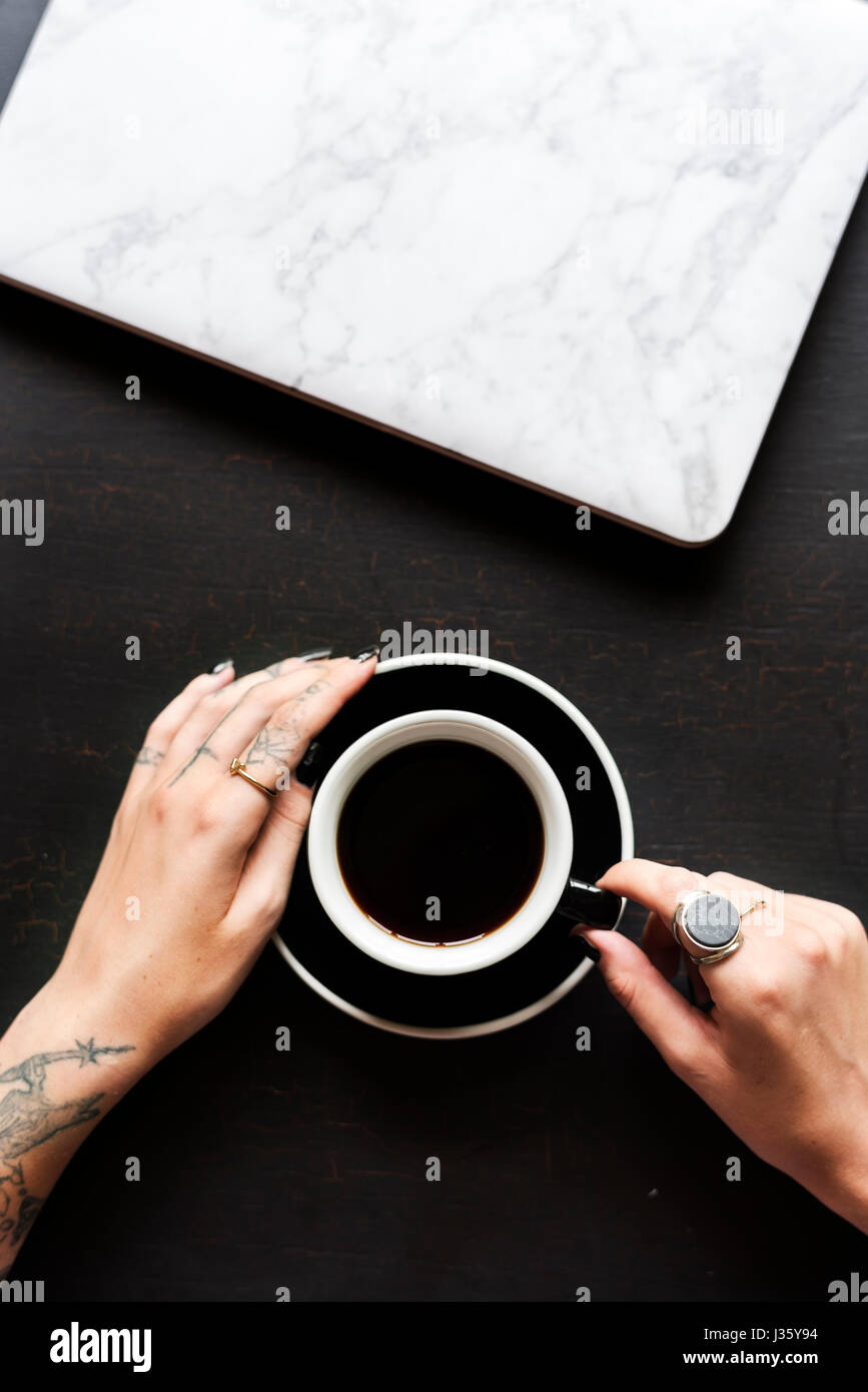 Tatuaggio mani con tazza di caffè bevanda Foto stock - Alamy