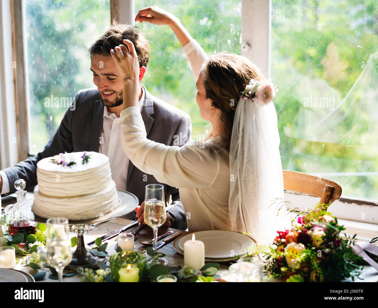 Sposa di toccare Imposta Groom capelli su ricevimento di nozze Foto Stock