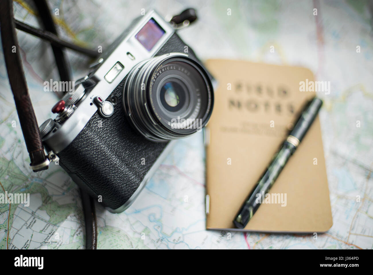 Fuji x100 fotocamera sulla mappa con il campo Note e notebook green Mabie Todd vintage fountain pen. Foto Stock