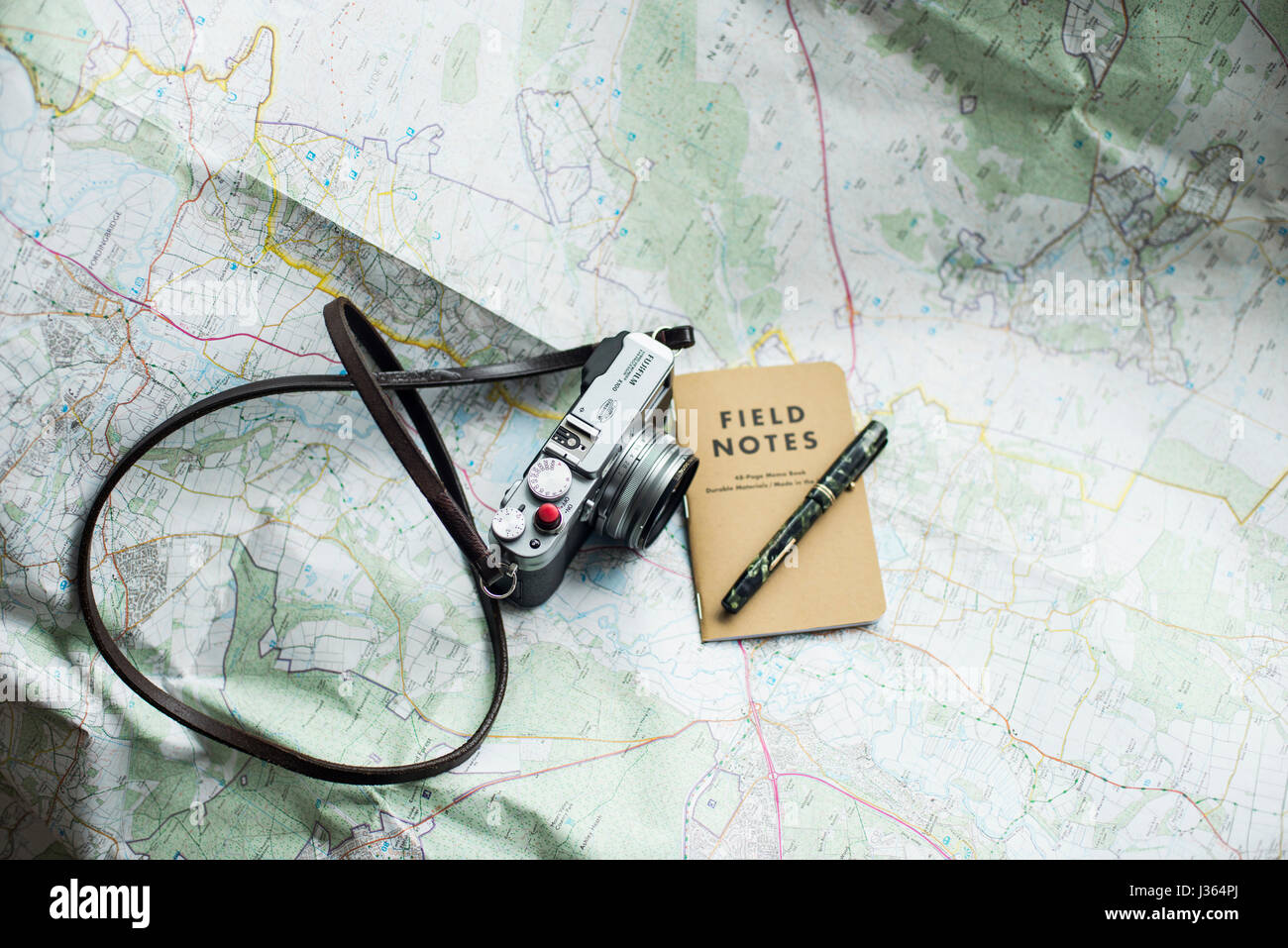 Fuji x100 fotocamera sulla mappa con il campo Note e notebook green Mabie Todd vintage fountain pen. Foto Stock