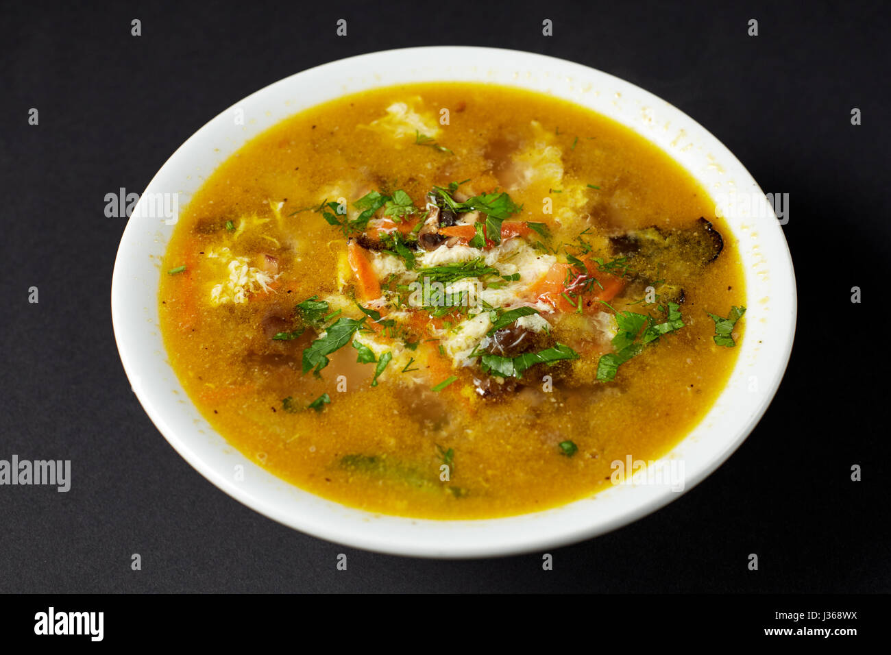 Minestra con fiore di uova. Cibo asiatico. Cucina asiatica. Studio shot sul buio o sfondo nero. Foto Stock