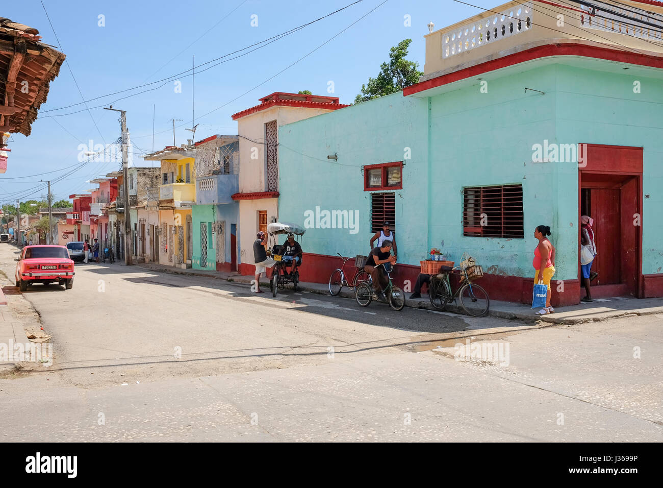 Strada locale vita in Trinidad, Sancti Spiritus, Cuba. Tipica scena da rurale di Cuba, con edifici color pastello, classic di auto e biciclette. Foto Stock