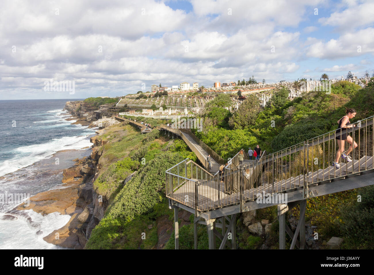 Un pareggiatore femmina scorre in alto passi sulle spiagge ad est il percorso costiero, Bronte, Sydney, Australia Foto Stock