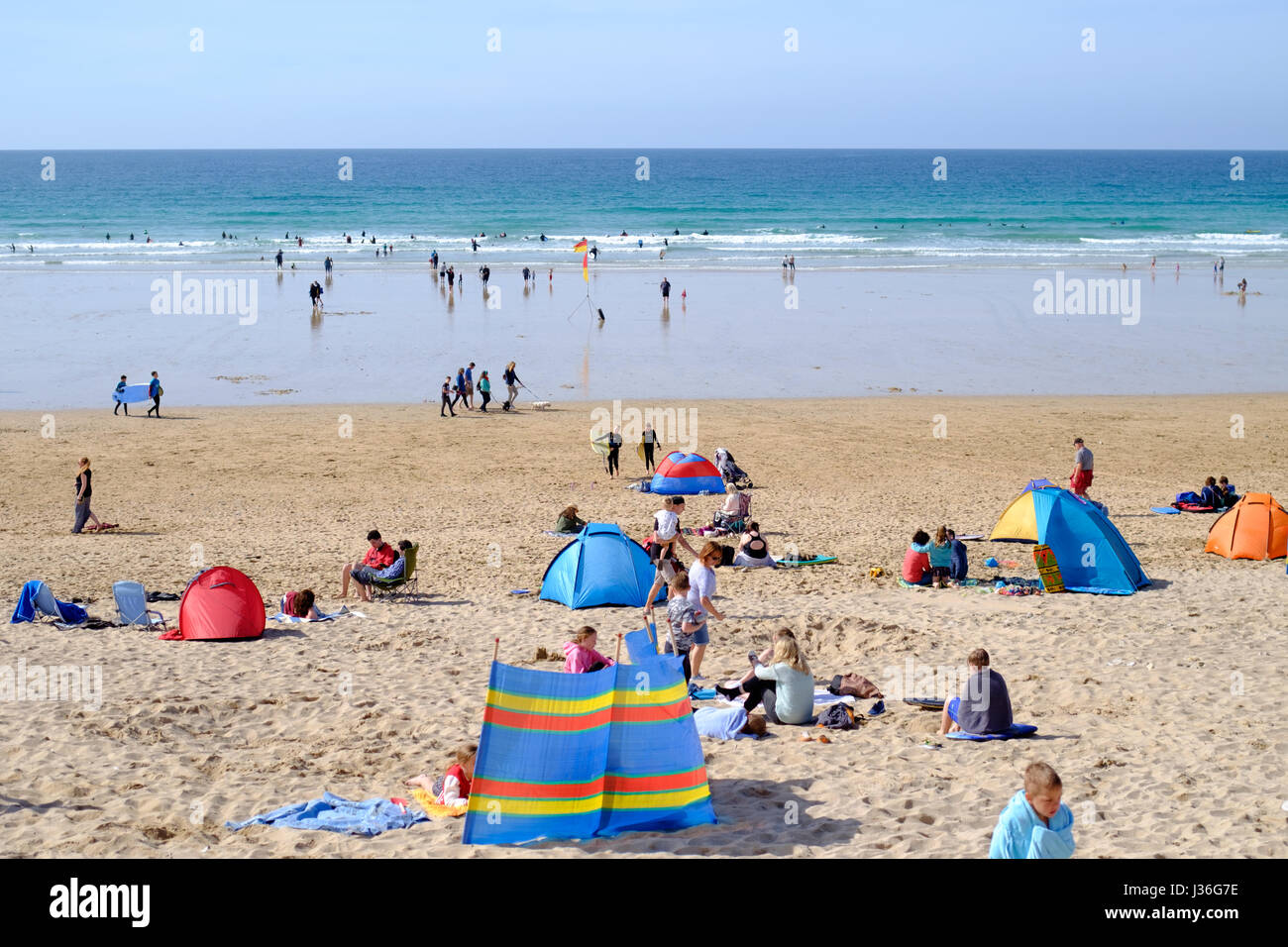 Newquay, Regno Unito. spiaggia frequentatori godetevi il sole in un ambiente luminoso e soleggiato nel pomeriggio a molla su Fistral Beach in Newquay. Foto Stock