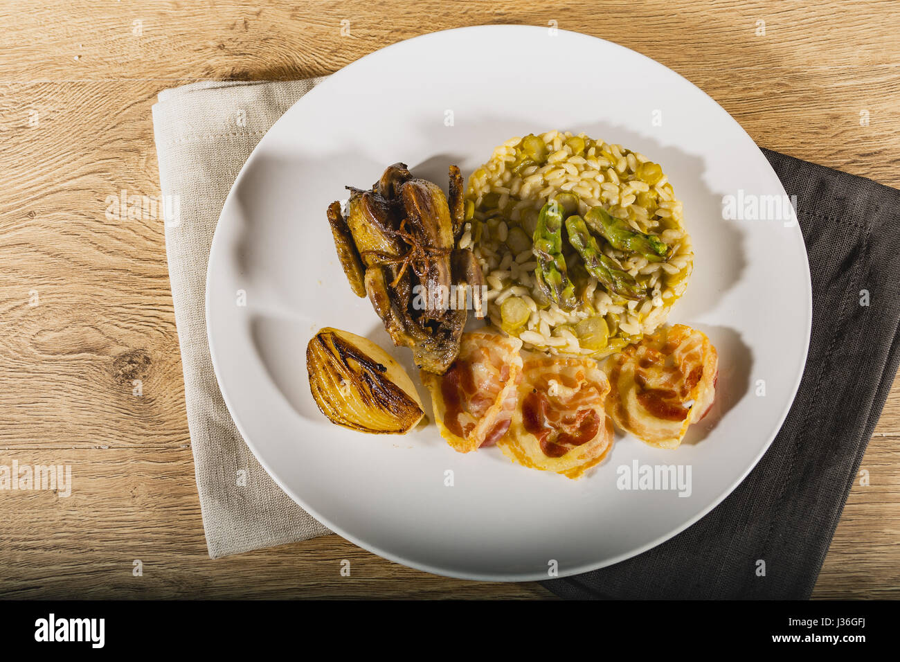 Piccione arrostito con asparagi verdi risotto e cipolla bianca e la pancetta da sopra Foto Stock