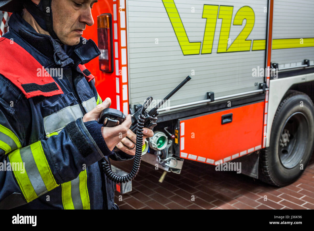 Vigile del fuoco utilizzato un walkie talkie in azione - HDR Foto Stock