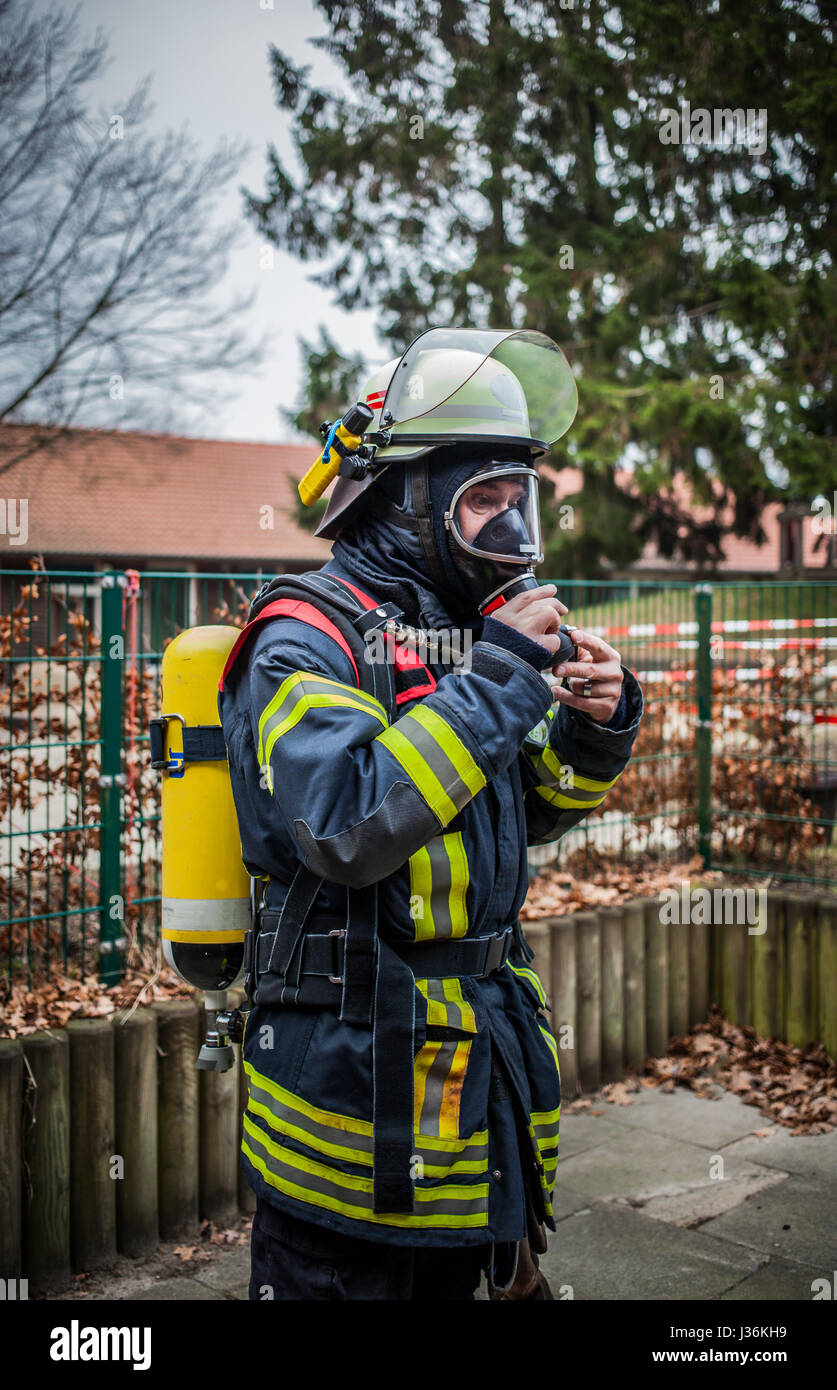 Vigile del fuoco all'aperto in azione con bottiglia di ossigeno e di protezione delle vie respiratorie maschera - HDR Foto Stock