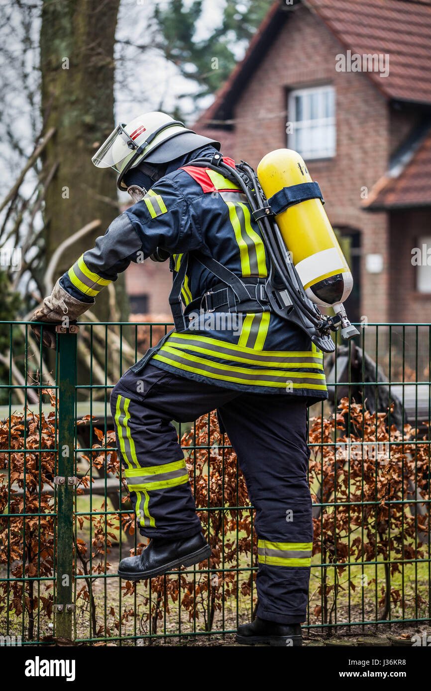 Vigile del Fuoco in azione all'aperto con le maschere di ossigeno e la bombola di ossigeno Foto Stock
