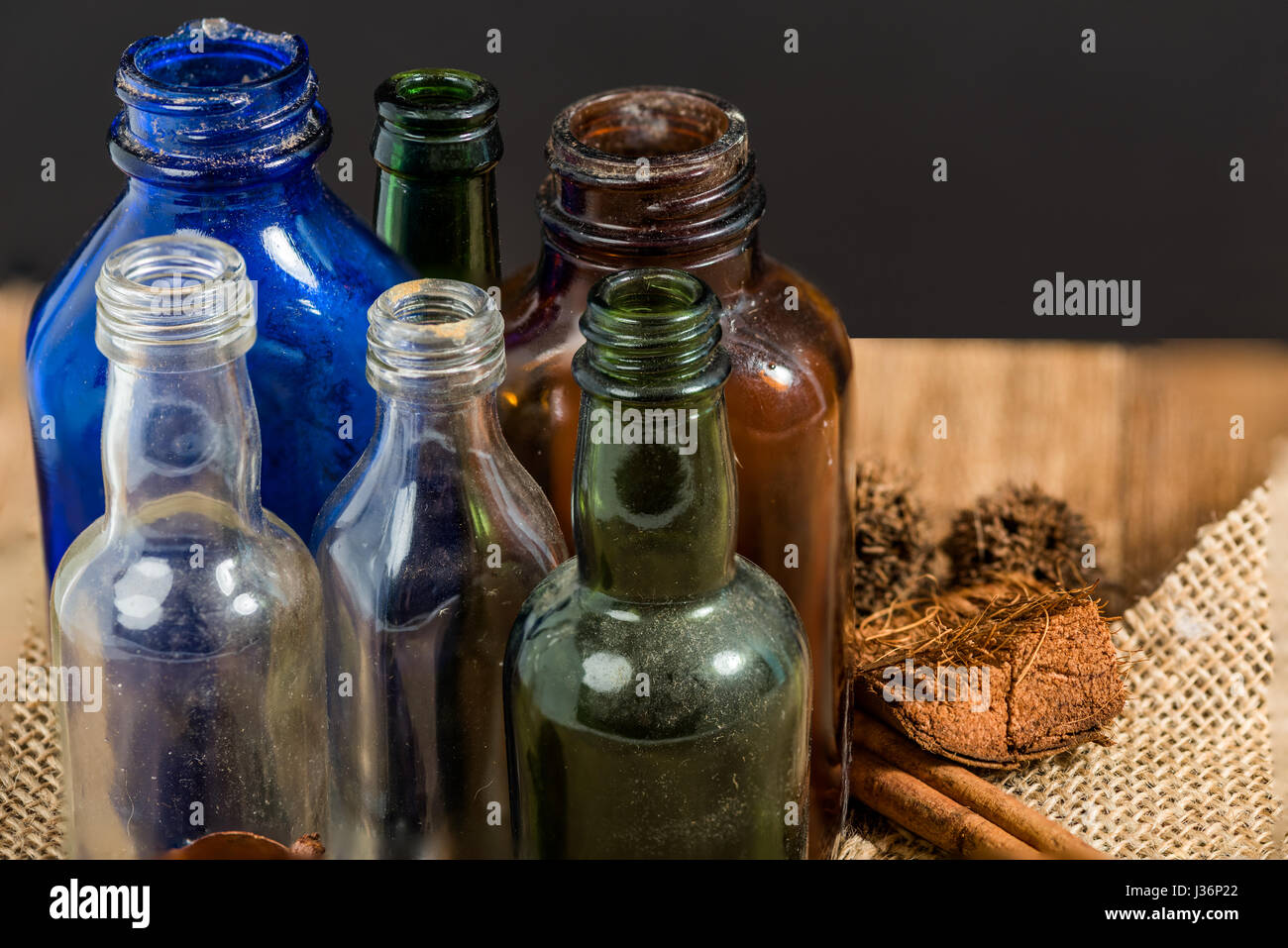 Vintage bottiglie raggruppate su una vecchia tela ruvida Foto Stock