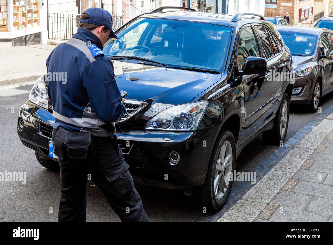Un vigile tenendo i dettagli di auto, High Street, Lewes, Sussex, Regno Unito Foto Stock