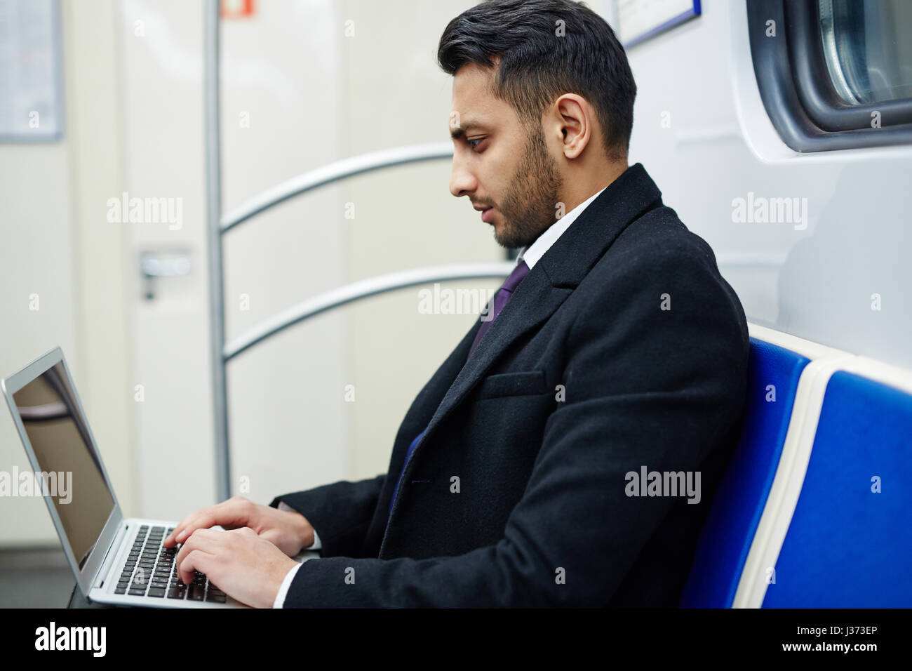 Uomo d'affari con computer portatile in metropolitana Foto Stock
