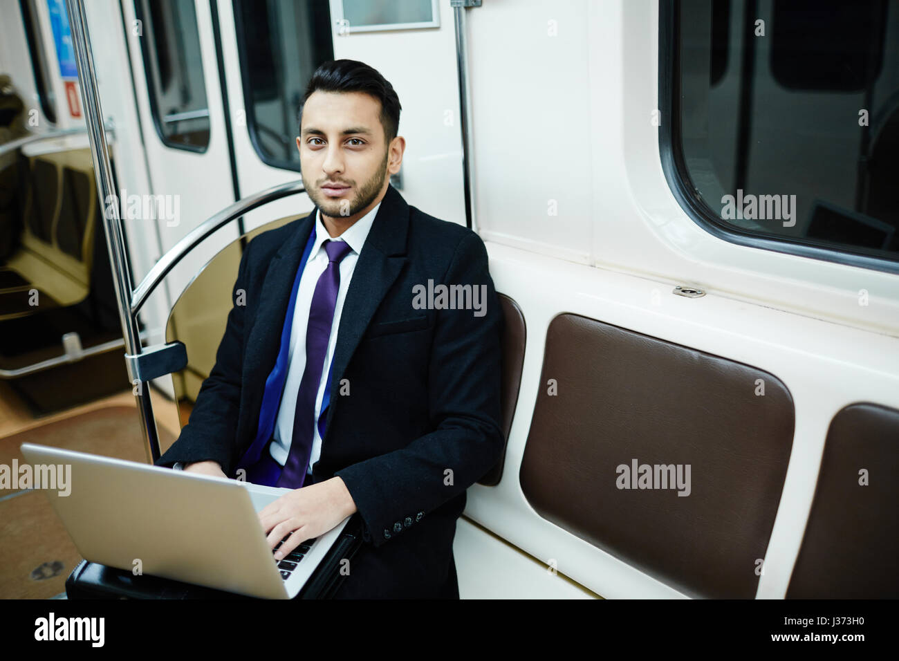 Imprenditore lavora con il computer portatile in metropolitana Foto Stock