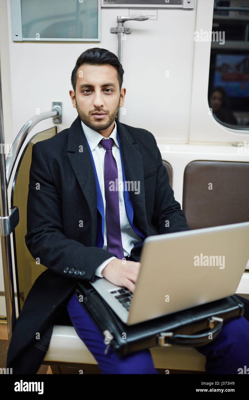 Bel uomo d affari con computer portatile in metropolitana Foto Stock