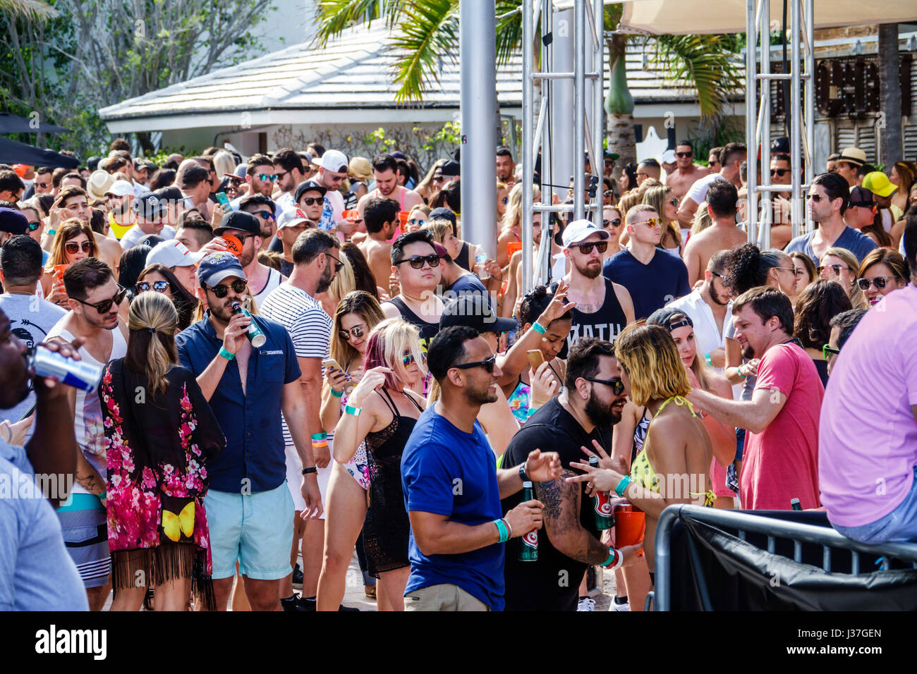 Miami Beach Florida,Miami Music Week,hotel pool party,folla,in piedi,balli,drink bevande bevande bevande bere,giovani adulti,uomini,donne,visitatori t Foto Stock