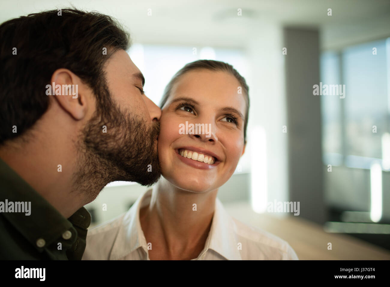 Close up di imprenditore kissing imprenditrice in office Foto Stock