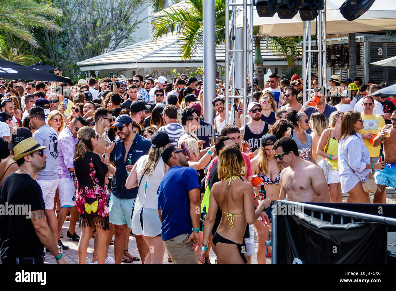 Miami Beach Florida,Miami Music Week,hotel pool party,folla,in piedi,balli,drink bevande bevande bevande bere,giovani adulti,uomini,donne,visitatori t Foto Stock