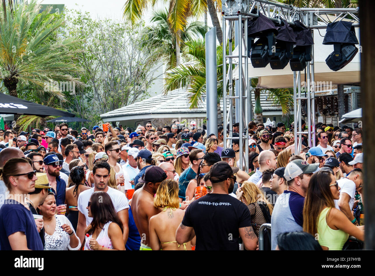 Miami Beach Florida,Miami Music Week,hotel pool party,folla,in piedi,balli,drink drink bere,giovane adulto,uomini,donne,palco,illuminazione,capriate,FL170326 Foto Stock