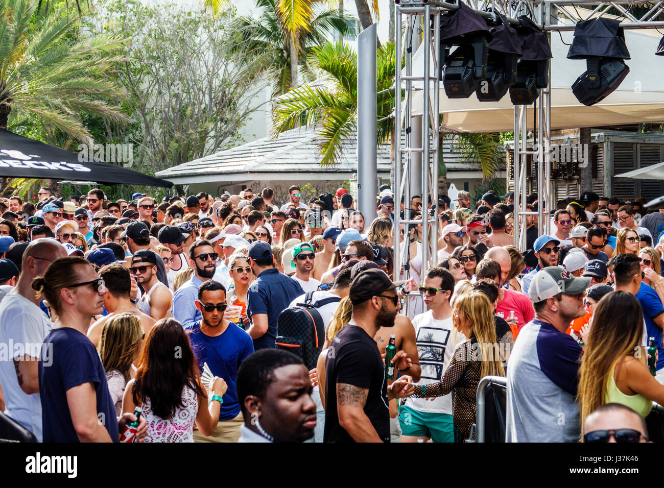 Miami Beach Florida, Miami Music Week, festa in piscina, folla, in piedi, danza, drink bevande bevande bevande bere, giovane adulto, uomini, donne, palco, illuminazione, t Foto Stock