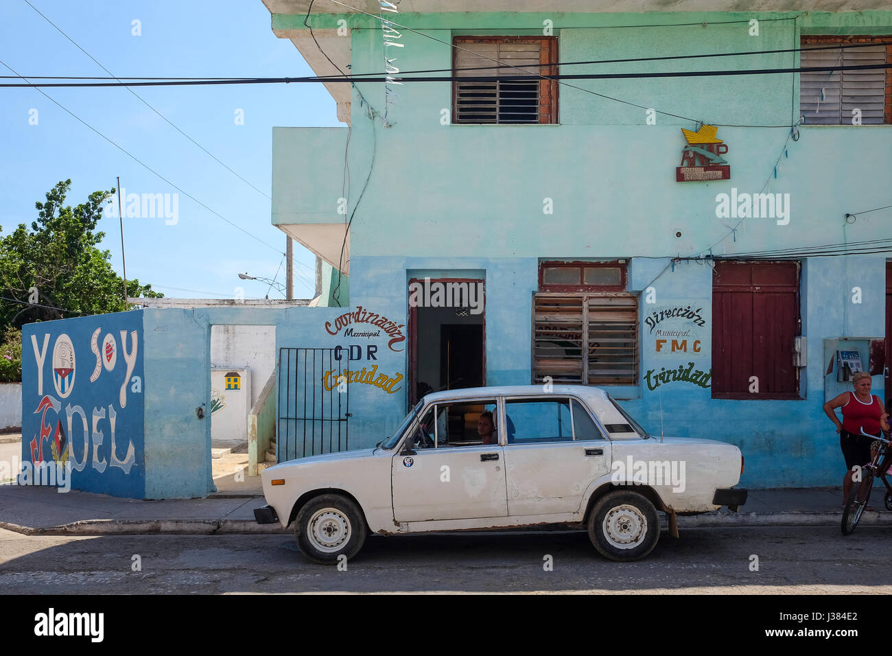 Vecchio classico auto parcheggiate sulle strade di Cuba, sullo sfondo di un dipinto murale di propaganda "sto Fidel' Foto Stock