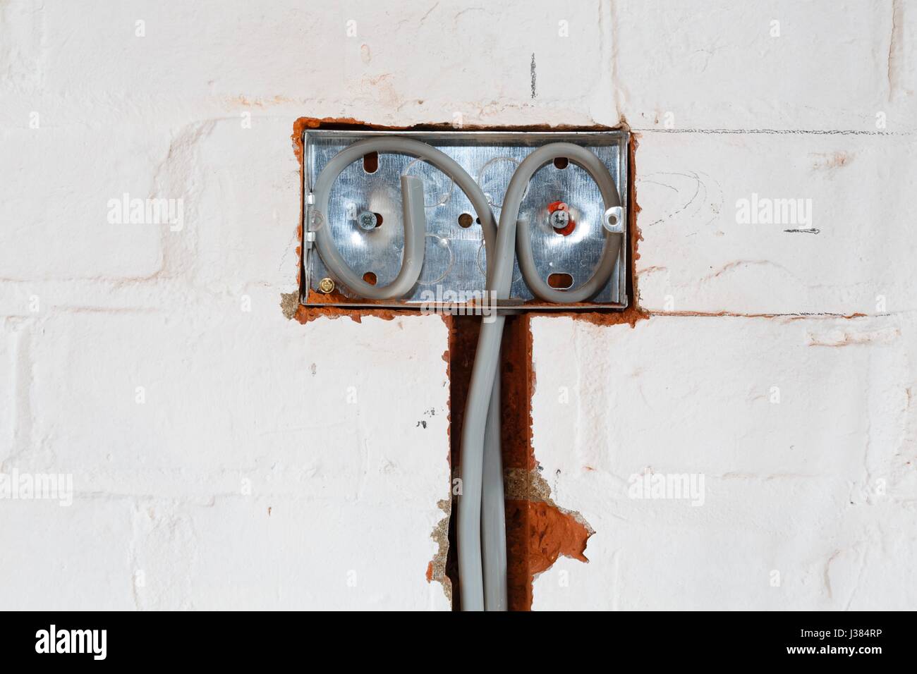 Regno Unito di installazione elettrica di una presa in un muro di una casa Foto Stock