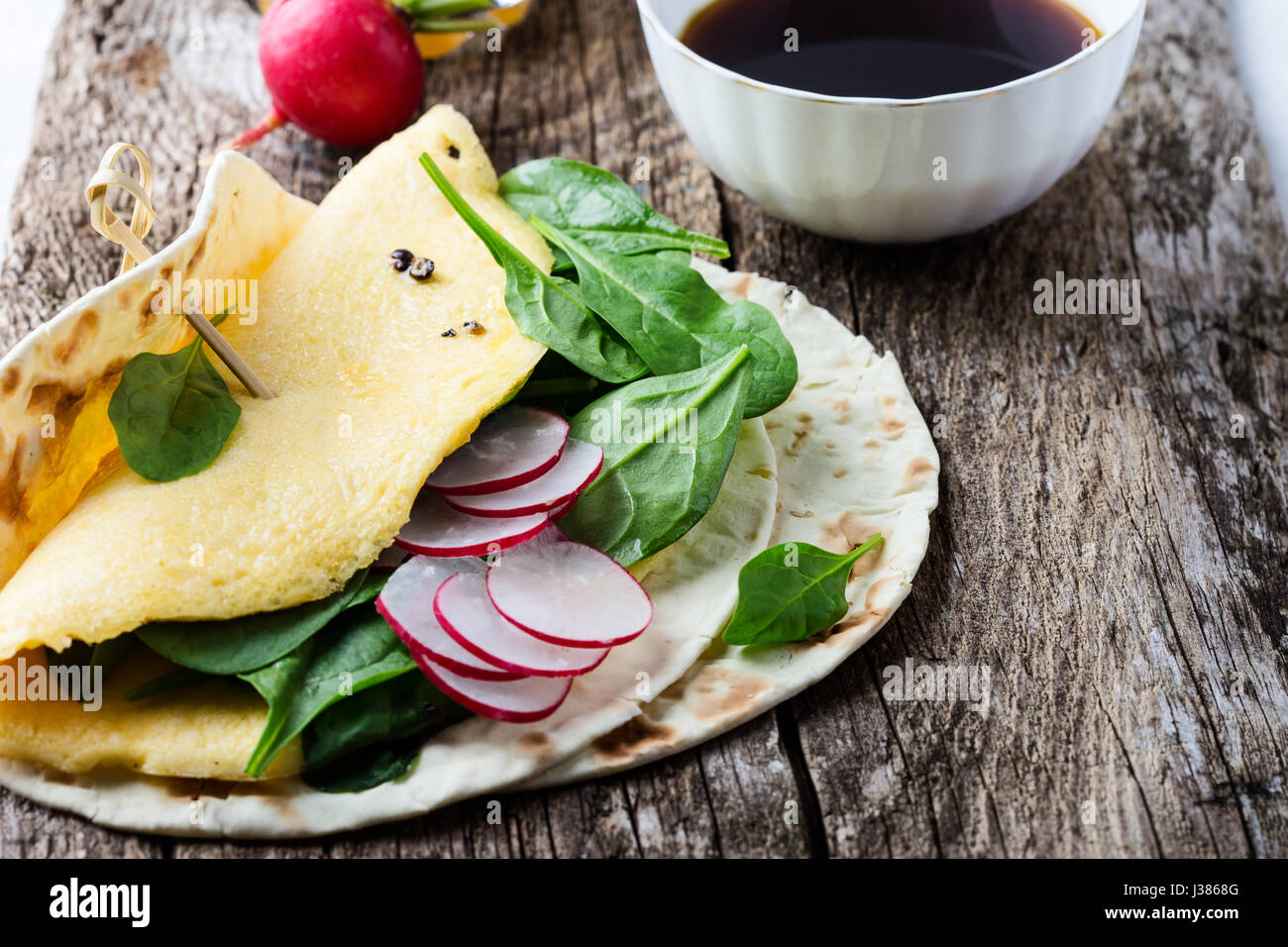 Tavolo da pranzo. In casa la frittata spinaci tacos su tavola in legno rustico, cibo messicano Foto Stock