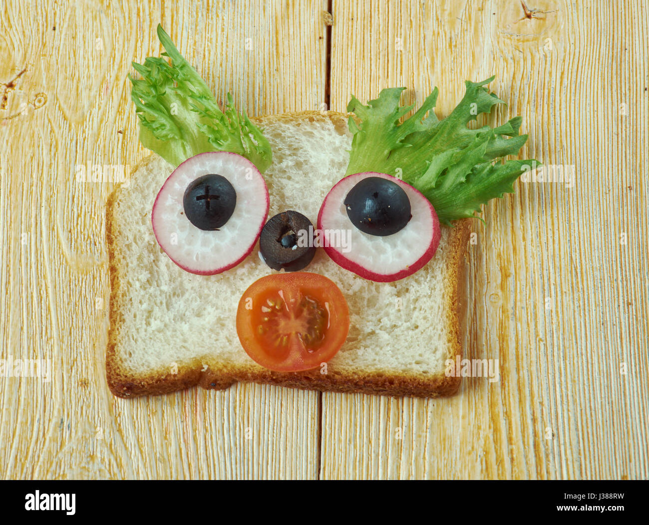 Cucina creativa concetto - sandwich divertenti per bambini uomo fatto di pane, toast, salsiccia, verdure Foto Stock