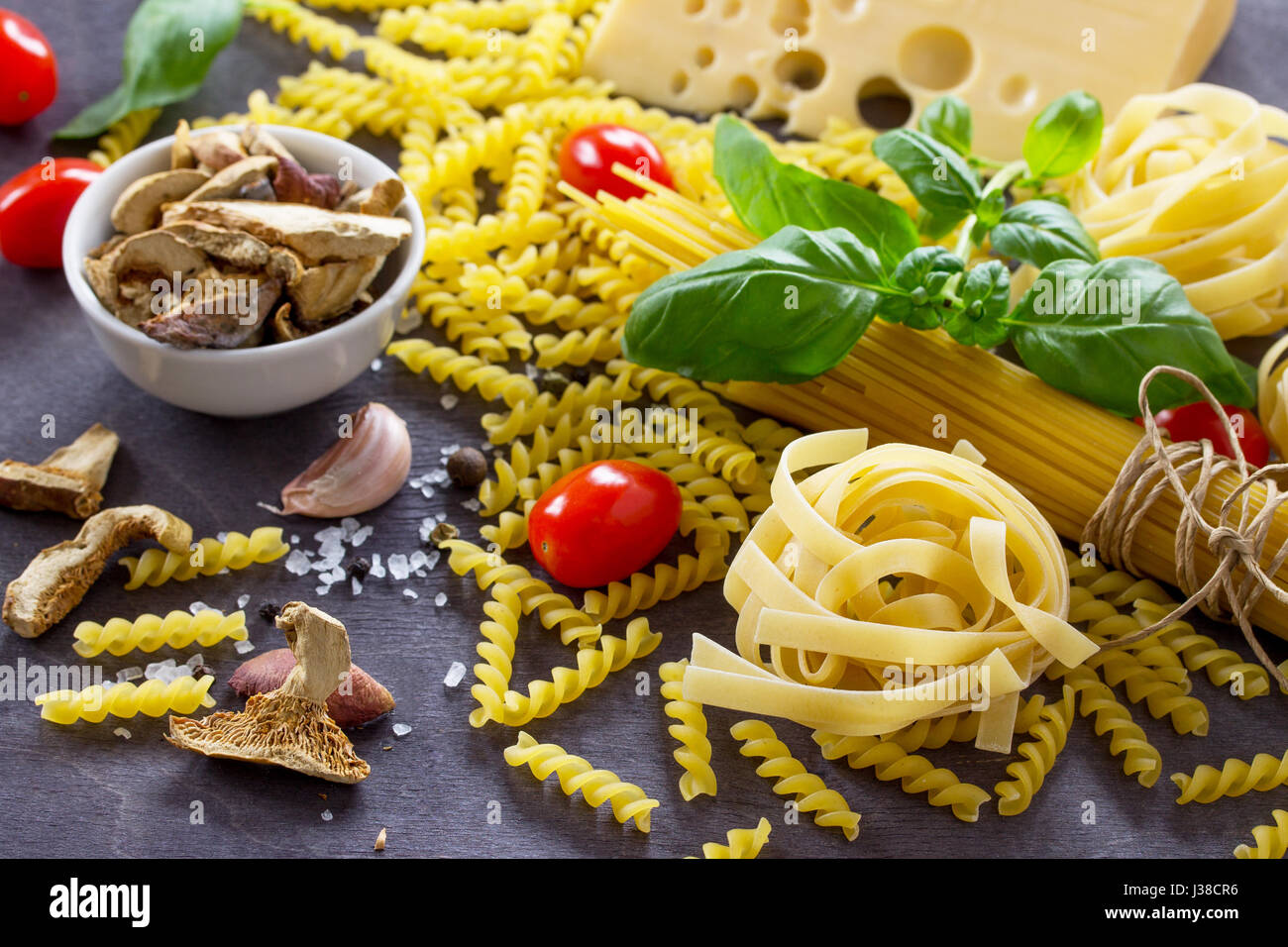 Diversi tipi di pasta con basilico in cucina un tavolo di legno. Foto Stock