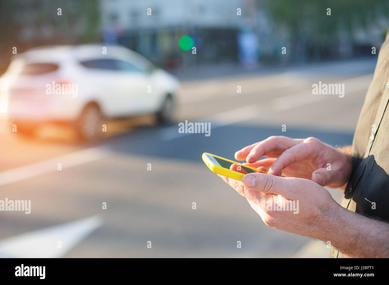 Uomo con un telefono in mano scrive un messaggio Foto Stock