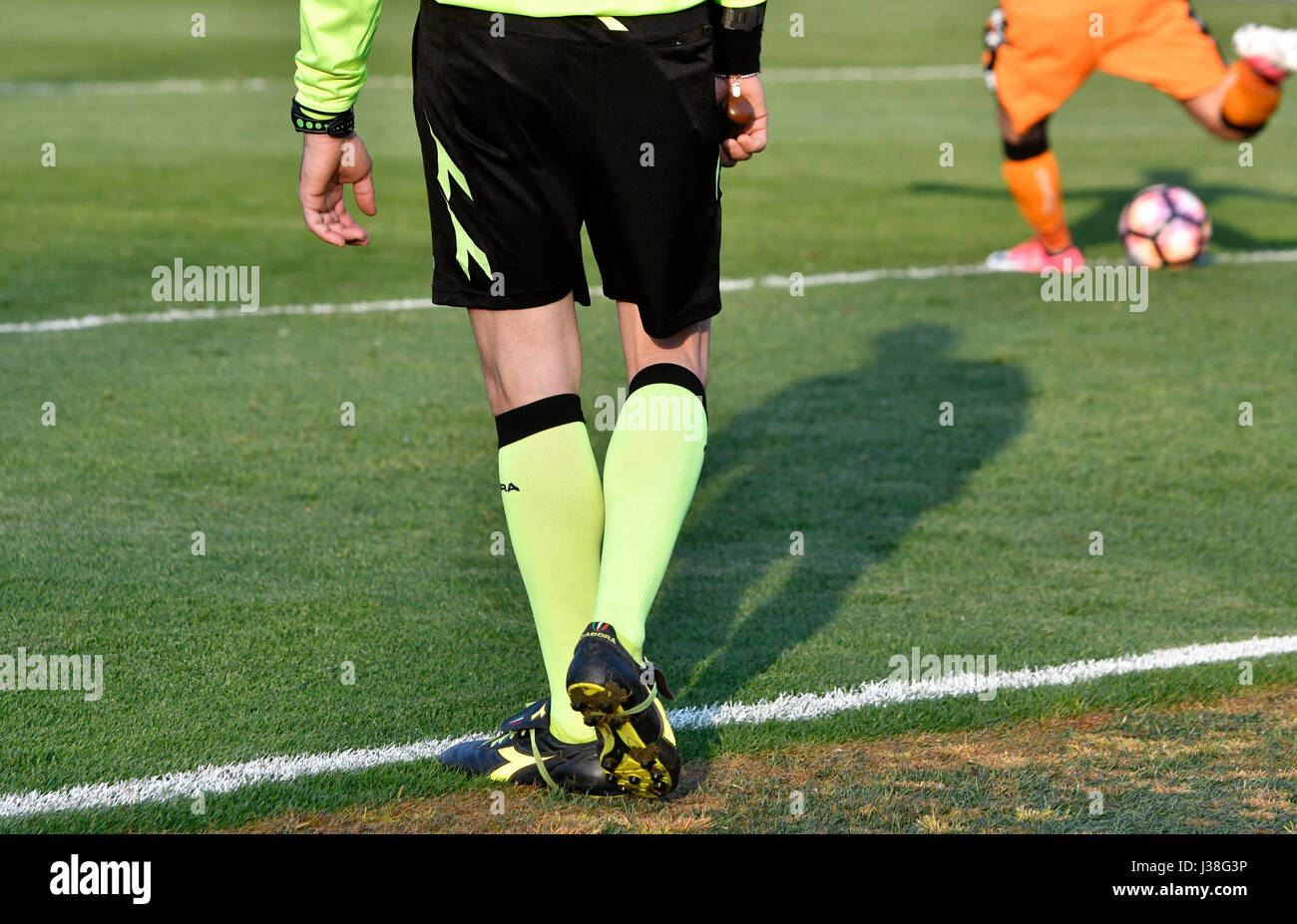 Giocatore di calcio vicino fino alle gambe, calciare la palla sul campo in erba. Foto Stock
