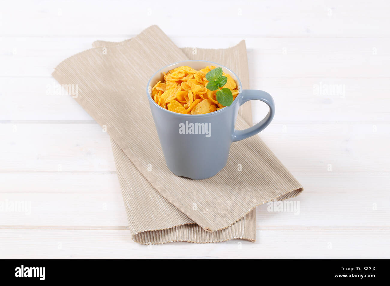 Tazza di fiocchi di mais sul posto beige mat Foto Stock