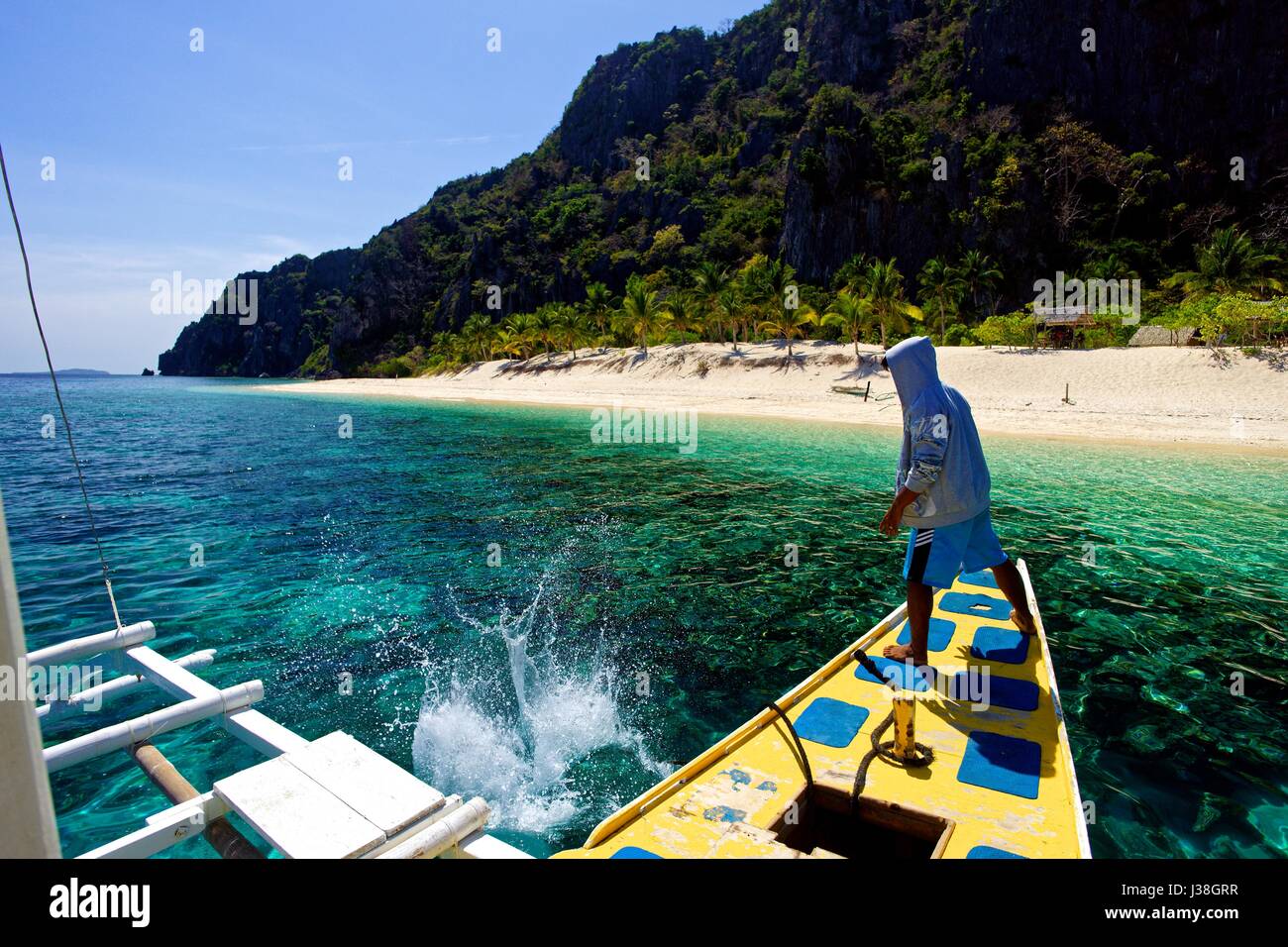 Barca di lanci a mano il dispositivo di ancoraggio fuori un outrigger motorizzata in barca, PALAWAN FILIPPINE a visitare un'isola privata. Foto Stock