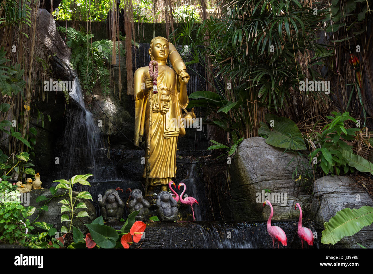 Golden statua del Buddha e piccole cascate artificiali al Golden Mount al Wat Saket a Bangkok, in Thailandia. Foto Stock