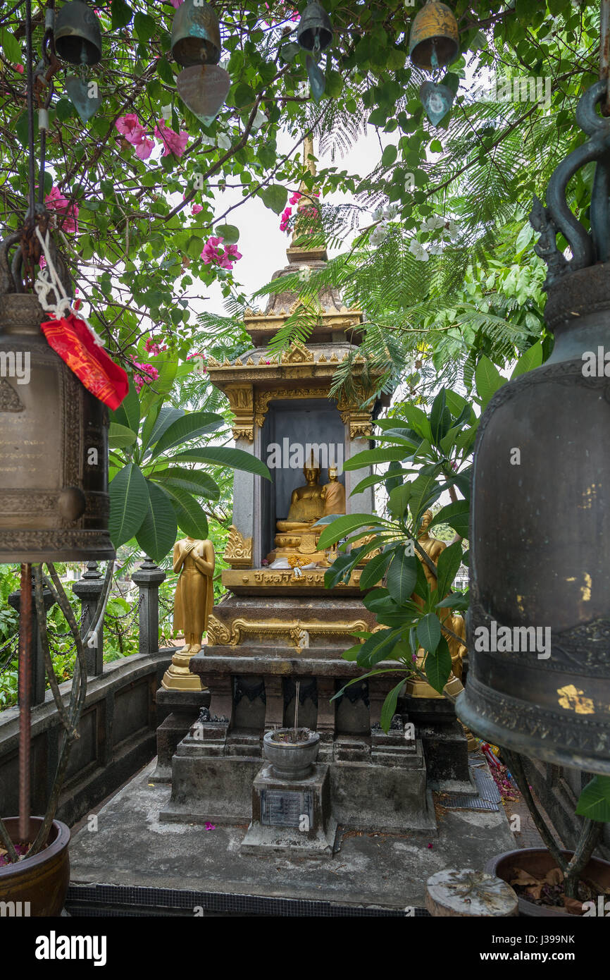 Golden Statue di Buddha e antiche campane in un piccolo santuario al Golden Mount al Wat Saket a Bangkok, in Thailandia. Foto Stock