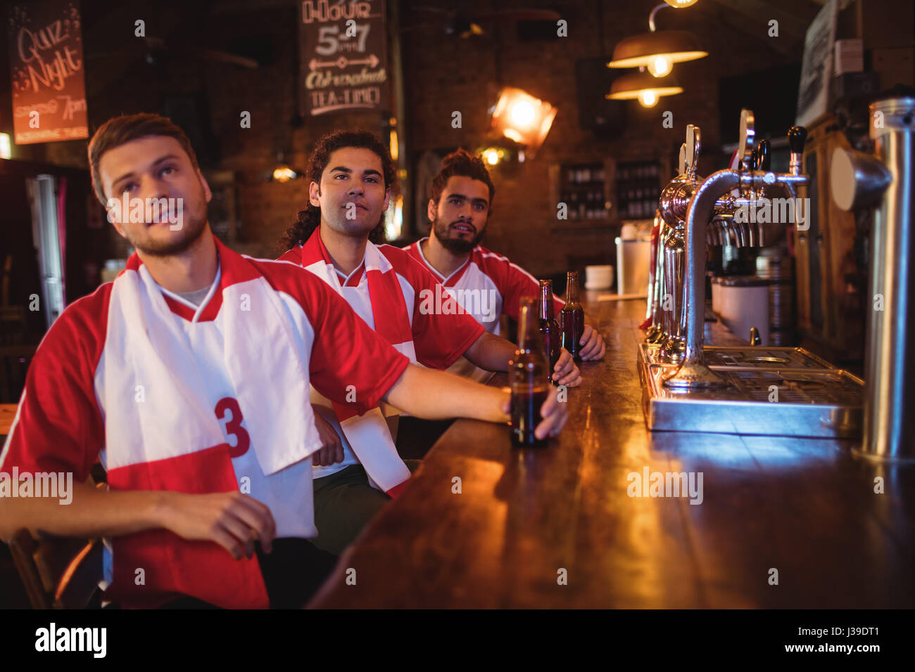 Gruppo di amici maschi guardando la partita di calcio in pub Foto Stock