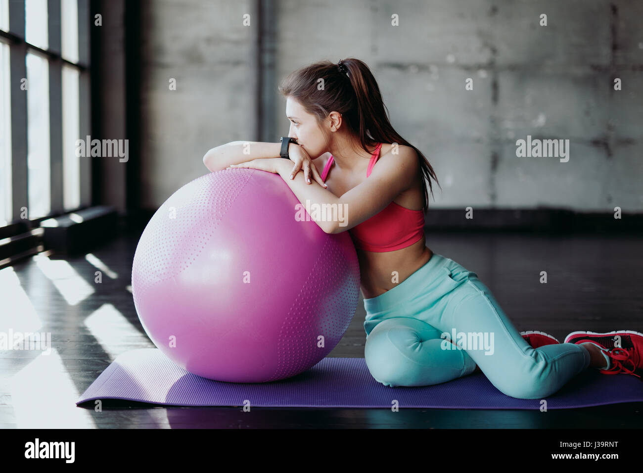 Fitness, sport, formazione e concetto di persone - donna sorridente flessione dei muscoli addominali con la palla ginnica in palestra Foto Stock