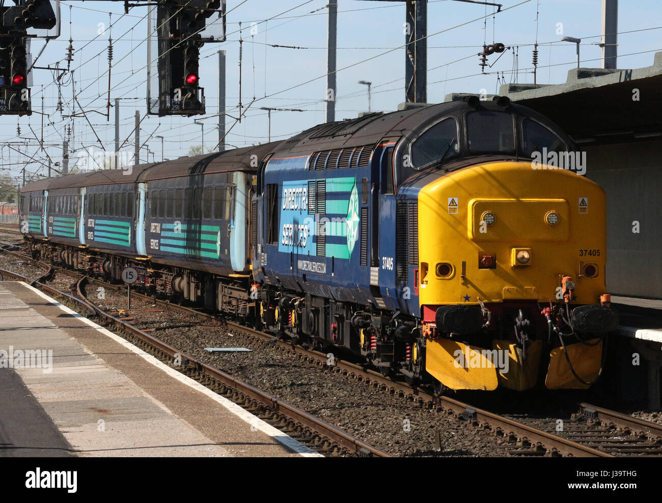 Classe 37 diesel locomotiva elettrica 37405 in livrea DRS con loco bolina treno passeggeri per il nord arrivando a Carnforth stazione ferroviaria. Foto Stock