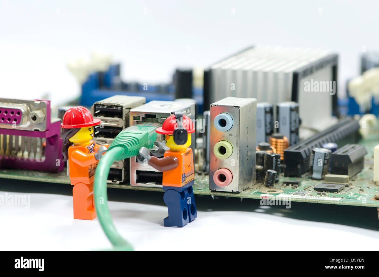 Lavoratore in miniatura plug in internet del cavo alla porta. Foto Stock