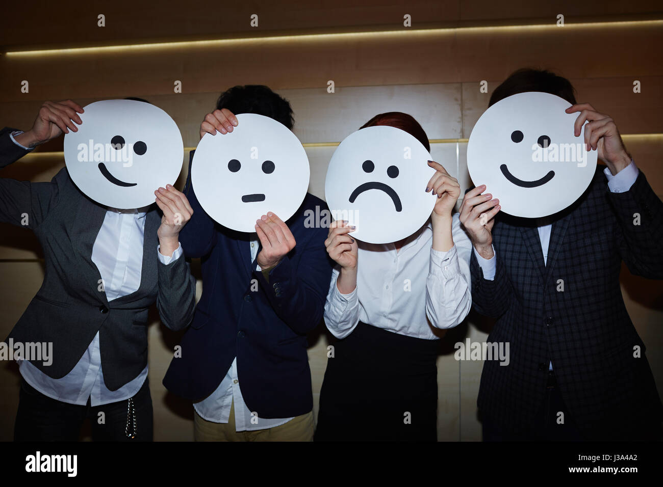 Ufficio lavoratori cercando su sorridente e triste maschere Foto Stock