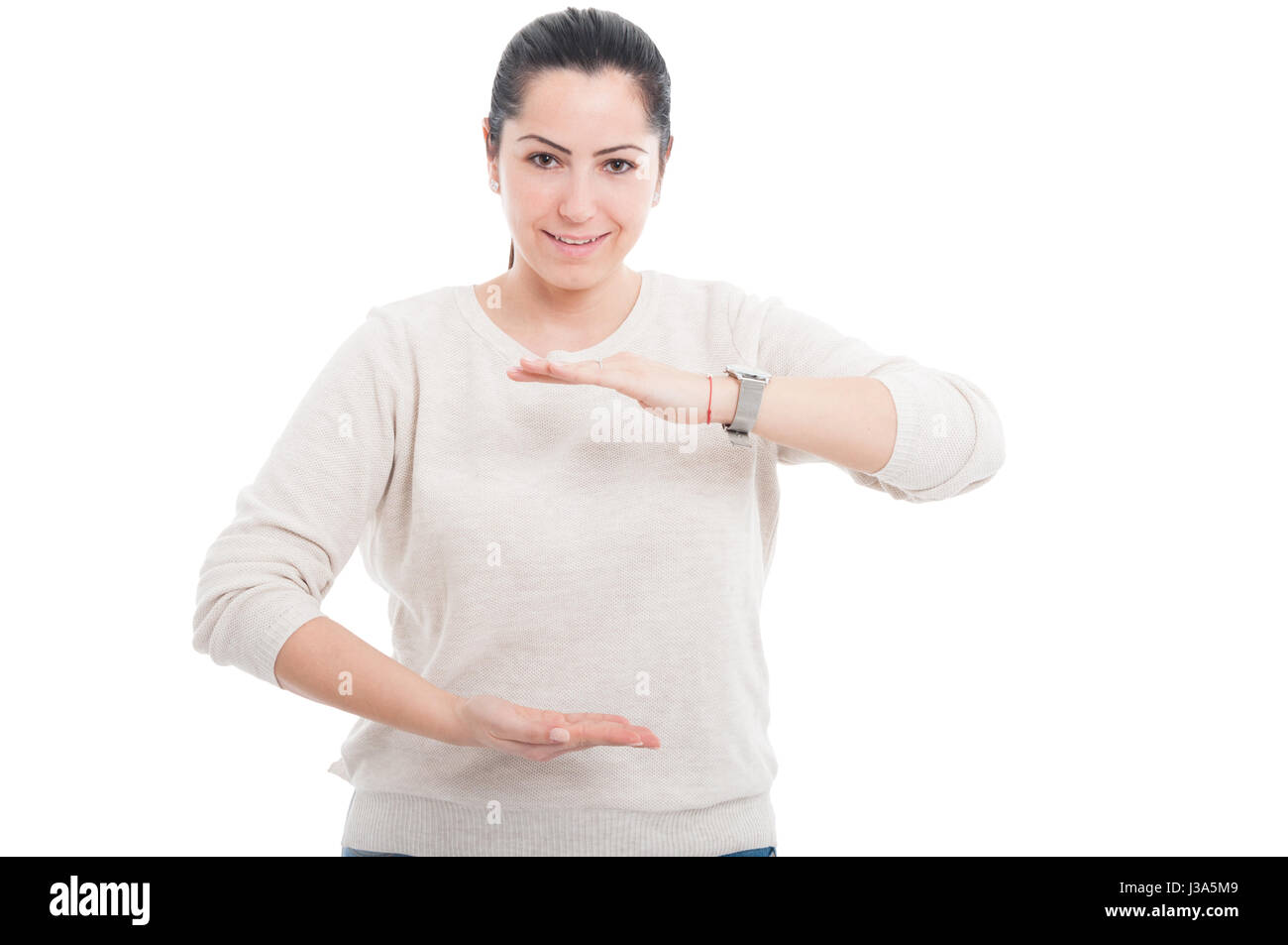 Giovane donna sorridente mostrando qualcosa di grande tra le sue mani con advetising zona isolata su bianco Foto Stock