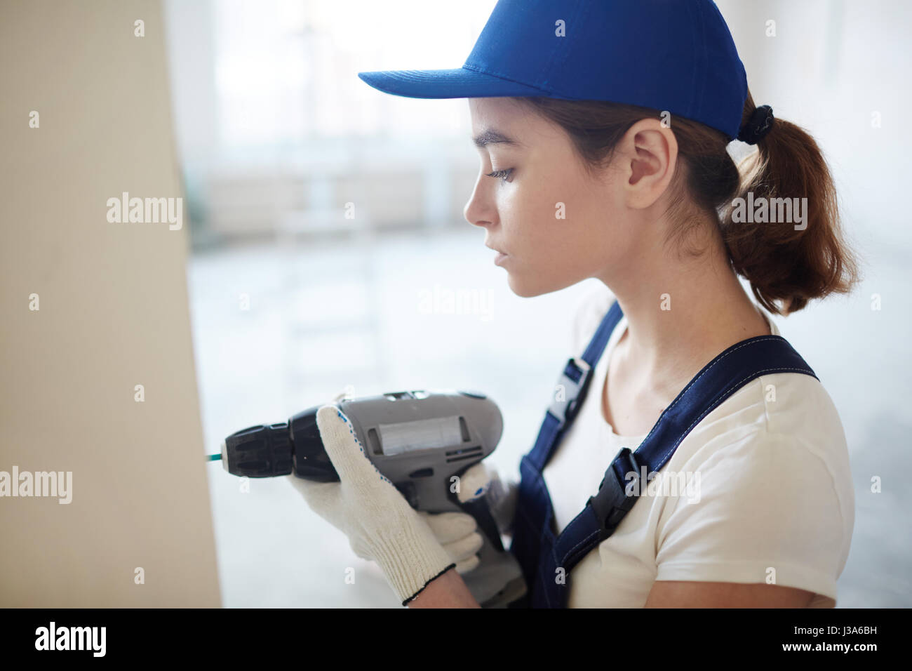 Donna pareti di fissaggio sul sito in costruzione Foto Stock