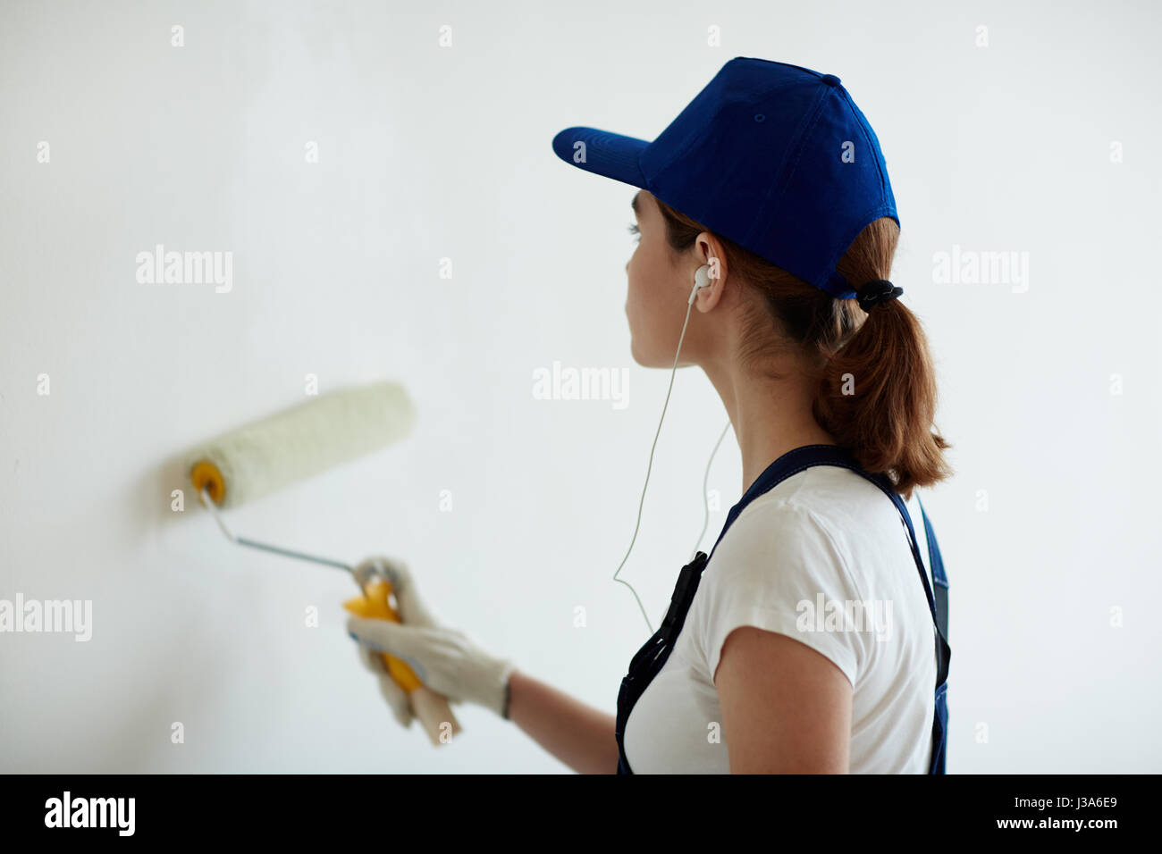 Donna pittura pareti con musica Foto Stock