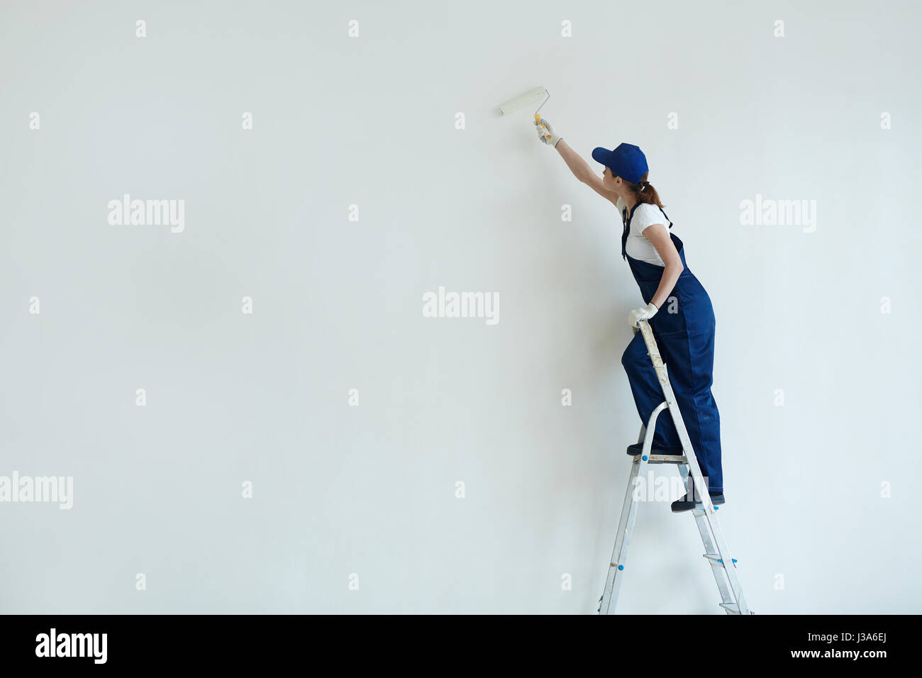 Donna pittura muro bianco Foto Stock