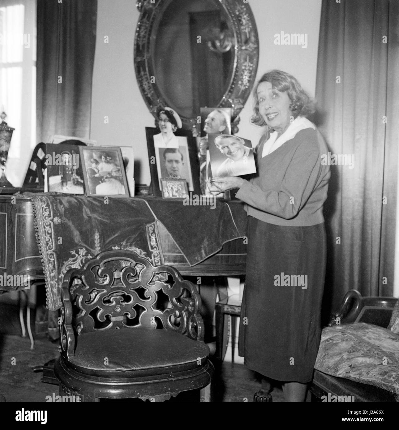 Mistinguette nel suo appartamento di Parigi si trova 24 Boulevard des Capucines, c.1955. Ella è in possesso di una foto del cantante francese Maurice Chevalier. Foto Stock