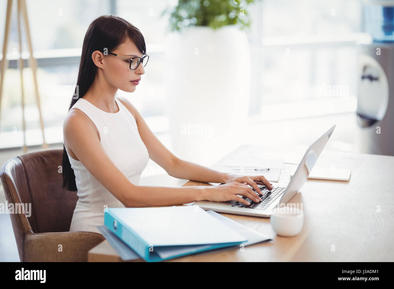 Esecutivo attento utilizzando laptop alla scrivania in ufficio Foto Stock