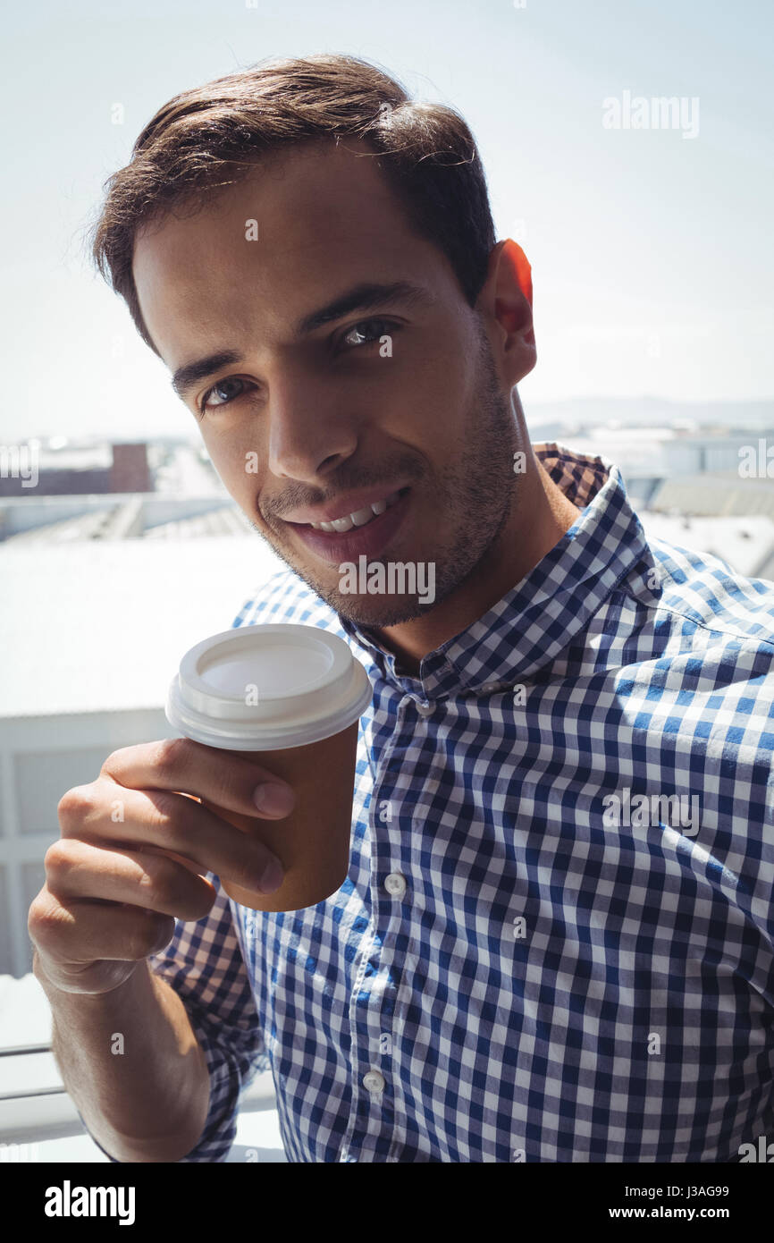 Close up ritratto di pensosa giovane impreditore azienda tazza di caffè dalla finestra di office Foto Stock